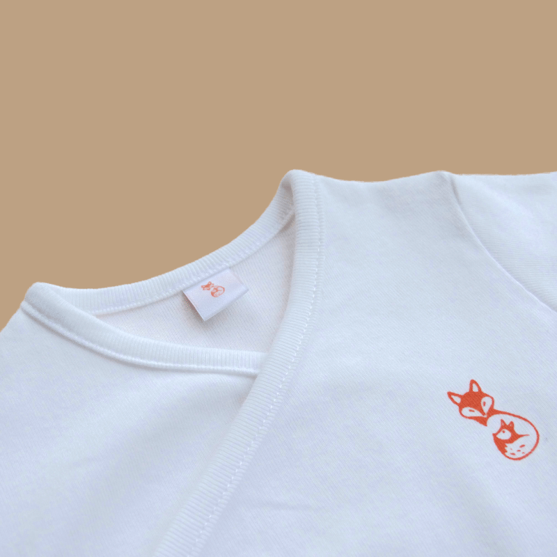 zoom body naissance blanc 3 et 6 mois à forme croisée vue étiquette et logo zoom body naissance blanc 3 et 6 mois à forme croisée vue étiquette et logo