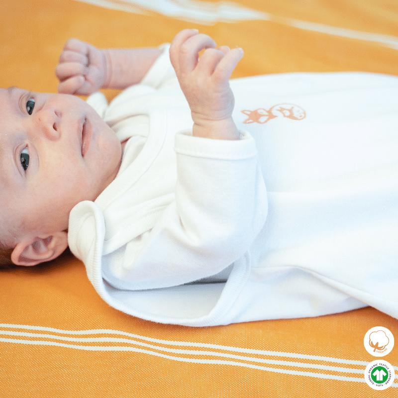 Gigoteuse été naissance blanche sans manche portée par un bébé de profil Gigoteuse été naissance blanche sans manche portée par un bébé de profil