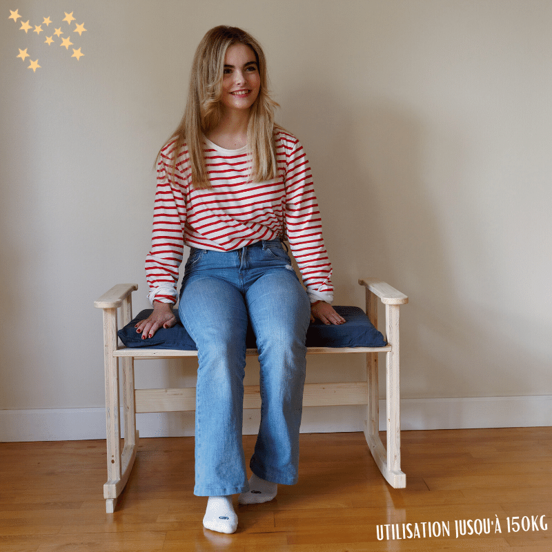 Adulte femme souriante et assise sur l'assise haute du support de berceau évolutif Adulte femme souriante et assise sur l'assise haute du support de berceau évolutif