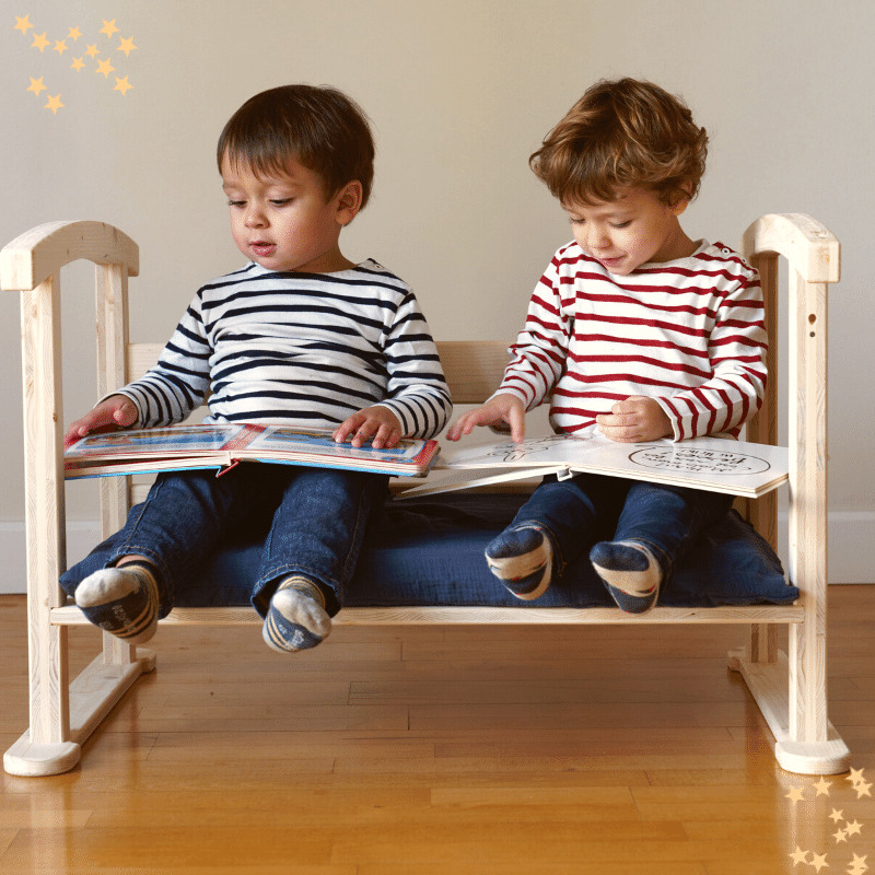 2 enfants assis sur le canapé enfant du berceau évolutif et lisant des livres 2 enfants assis sur le canapé enfant du berceau évolutif et lisant des livres