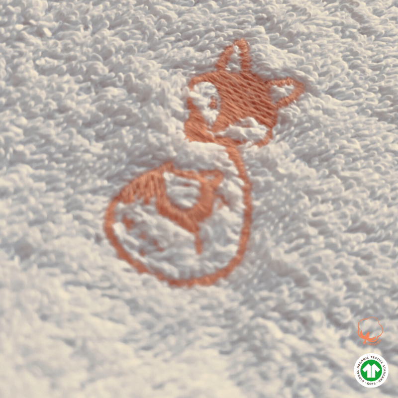 zoom sur logo de Serviette de bain bébé blanc coton bio GOTS zoom sur logo de Serviette de bain bébé blanc coton bio GOTS